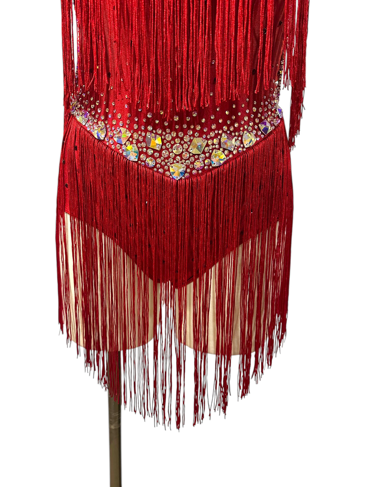 Close-up of red fringe dance costume with crystal waistband, AB statement stones, rhinestones, and layered fringe at the hips.