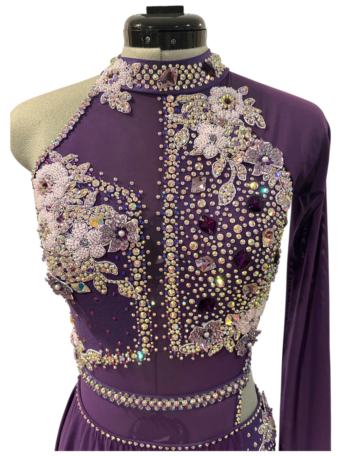 Close-up of purple dance costume featuring rhinestone appliqué, choker neckline, and competition-ready detailing