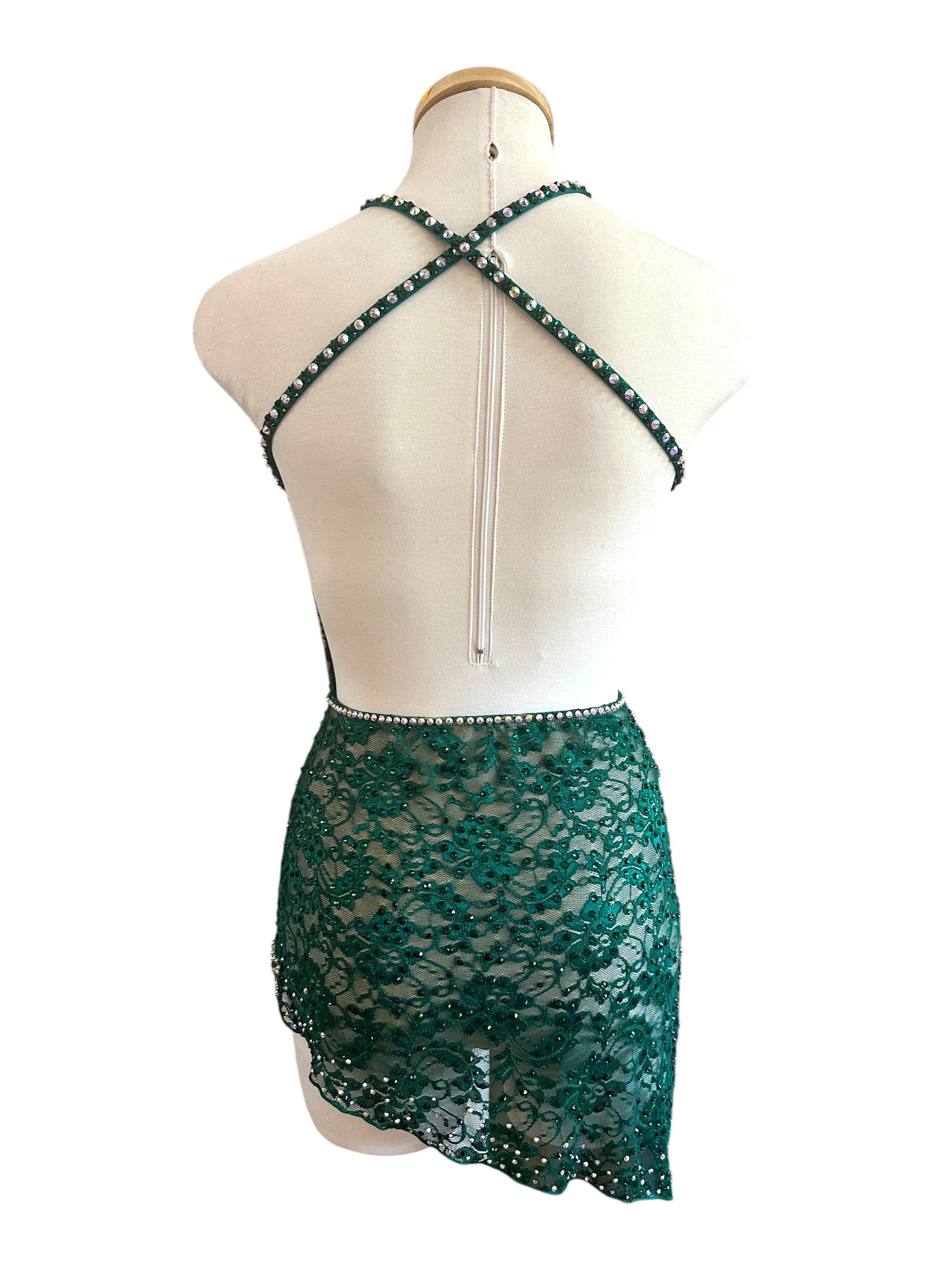 Back view of emerald green lace dance costume with open-back crisscross straps and asymmetrical lace skirt