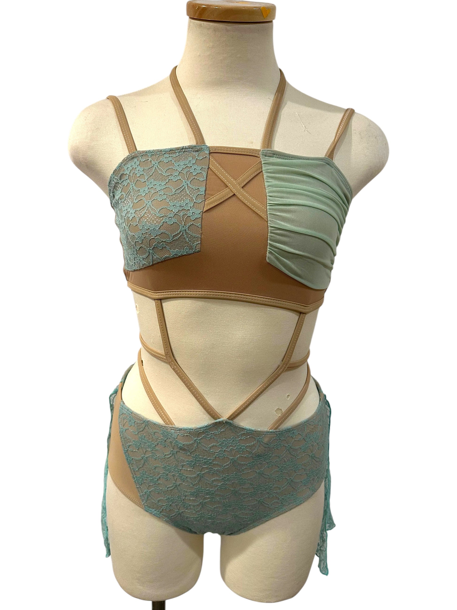 Ava dance costume base in Aqua with wrap-style lace bodice, nude illusion panels, and dramatic cutout competition design