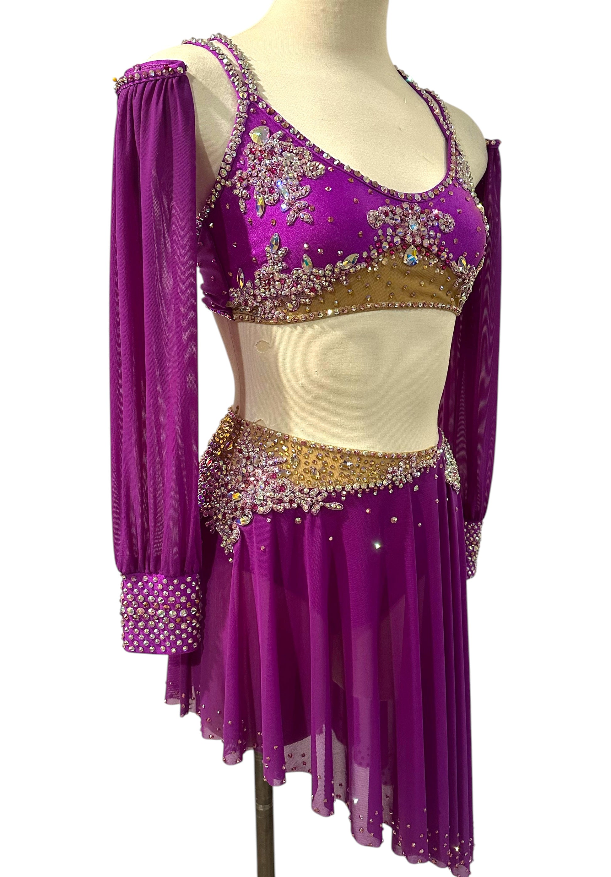 Detailed view of the asymmetrical fuchsia mesh skirt with crystal embellished waistband.