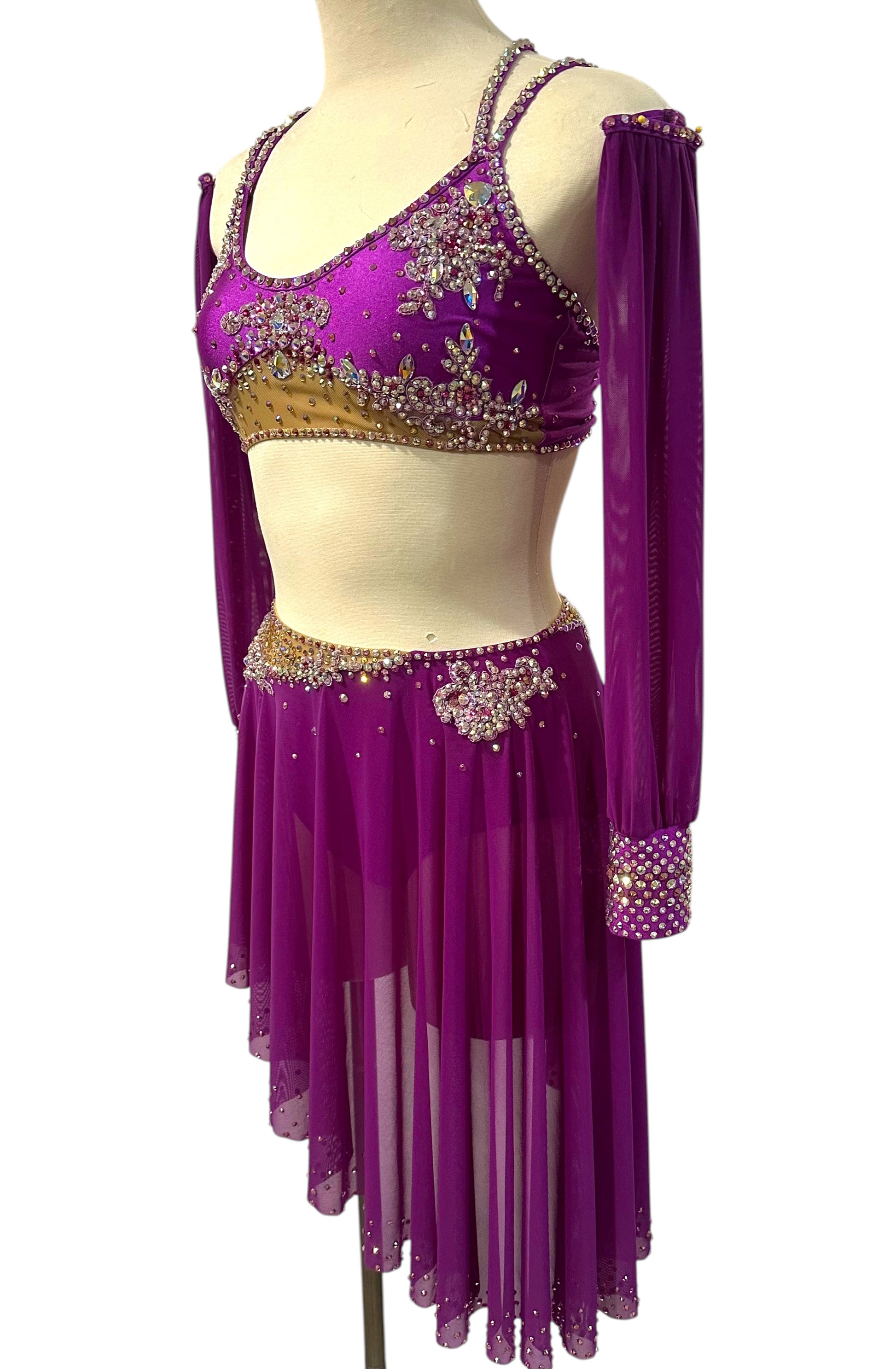 Side view of fuchsia rhinestone dance costume with detachable sleeves and flowing asymmetrical skirt.