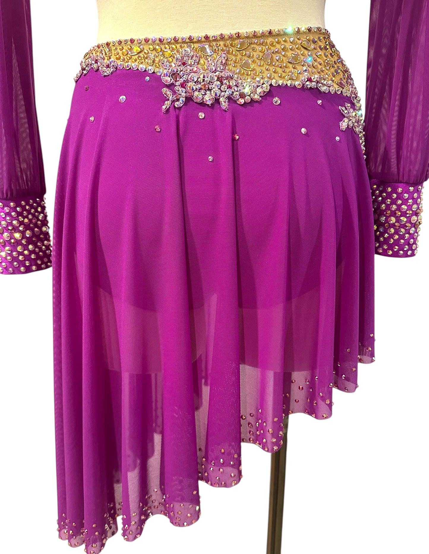 Rear view of a fuchsia two-piece dance costume with flowing asymmetrical mesh skirt and crystal embellishments.