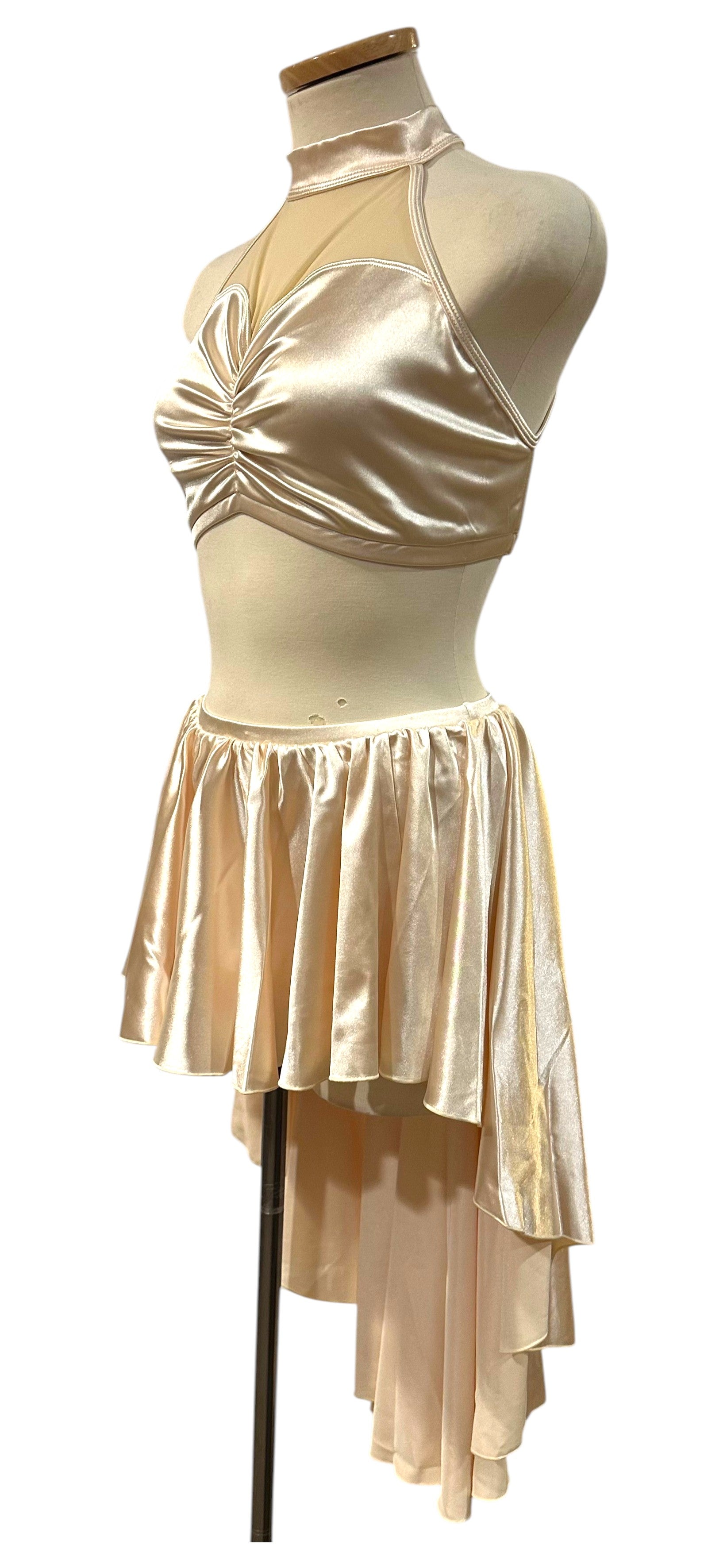 Angled front view of The Aubrey Base featuring luxurious satin fabric, illusion mesh, mock neckline, and layered asymmetrical skirt.
