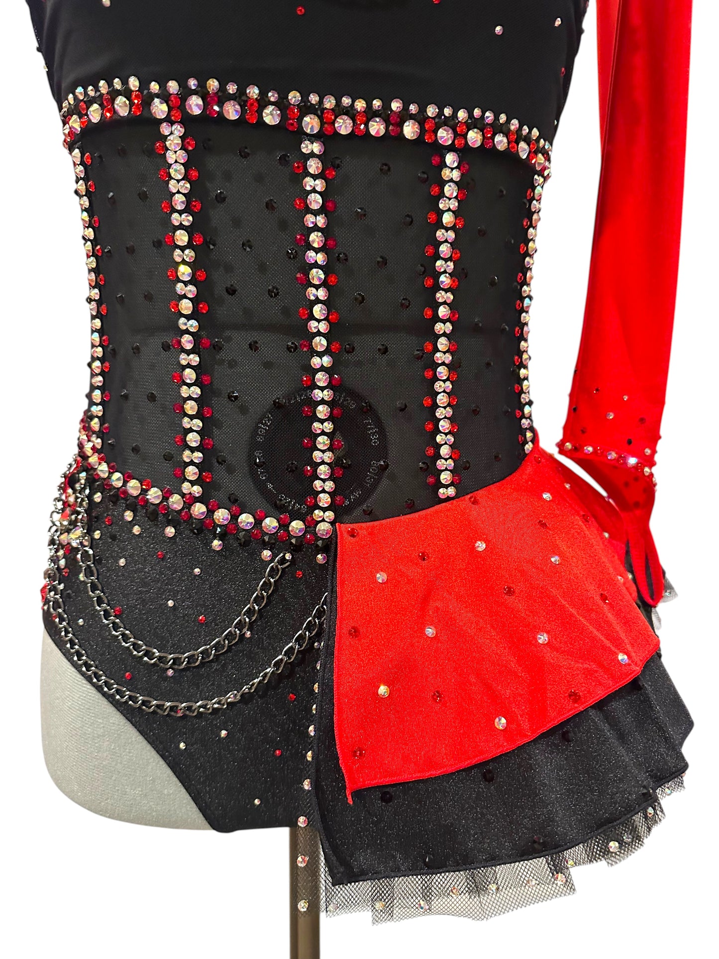 Close-up of the illusion mesh corset bodice with premium rhinestones, decorative chain accents, and a red satin peplum over a black tulle skirt.