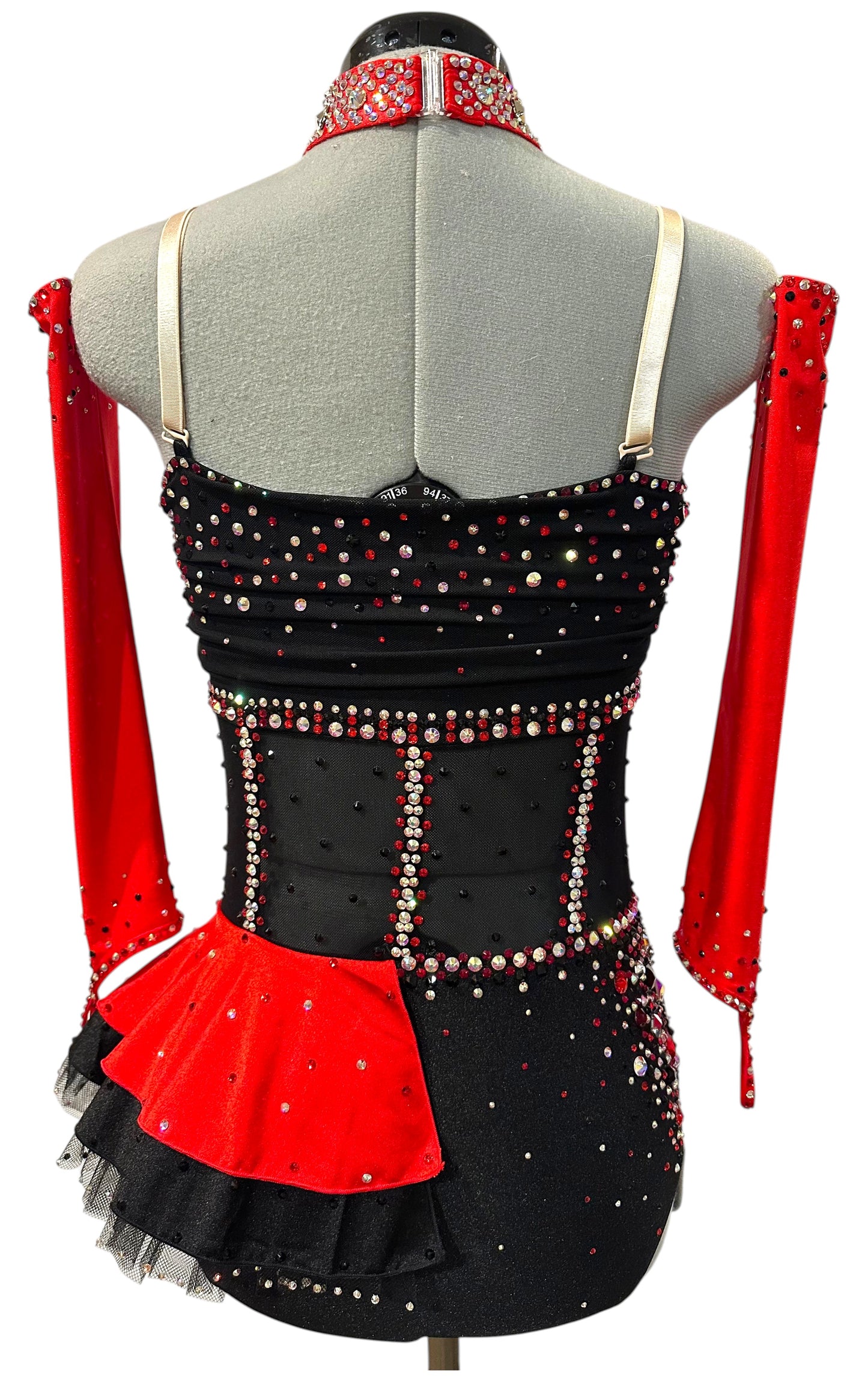 Back three-quarter view of a black and red rhinestone dance costume featuring chain accents, illusion mesh, detachable sleeves, and a red satin peplum.