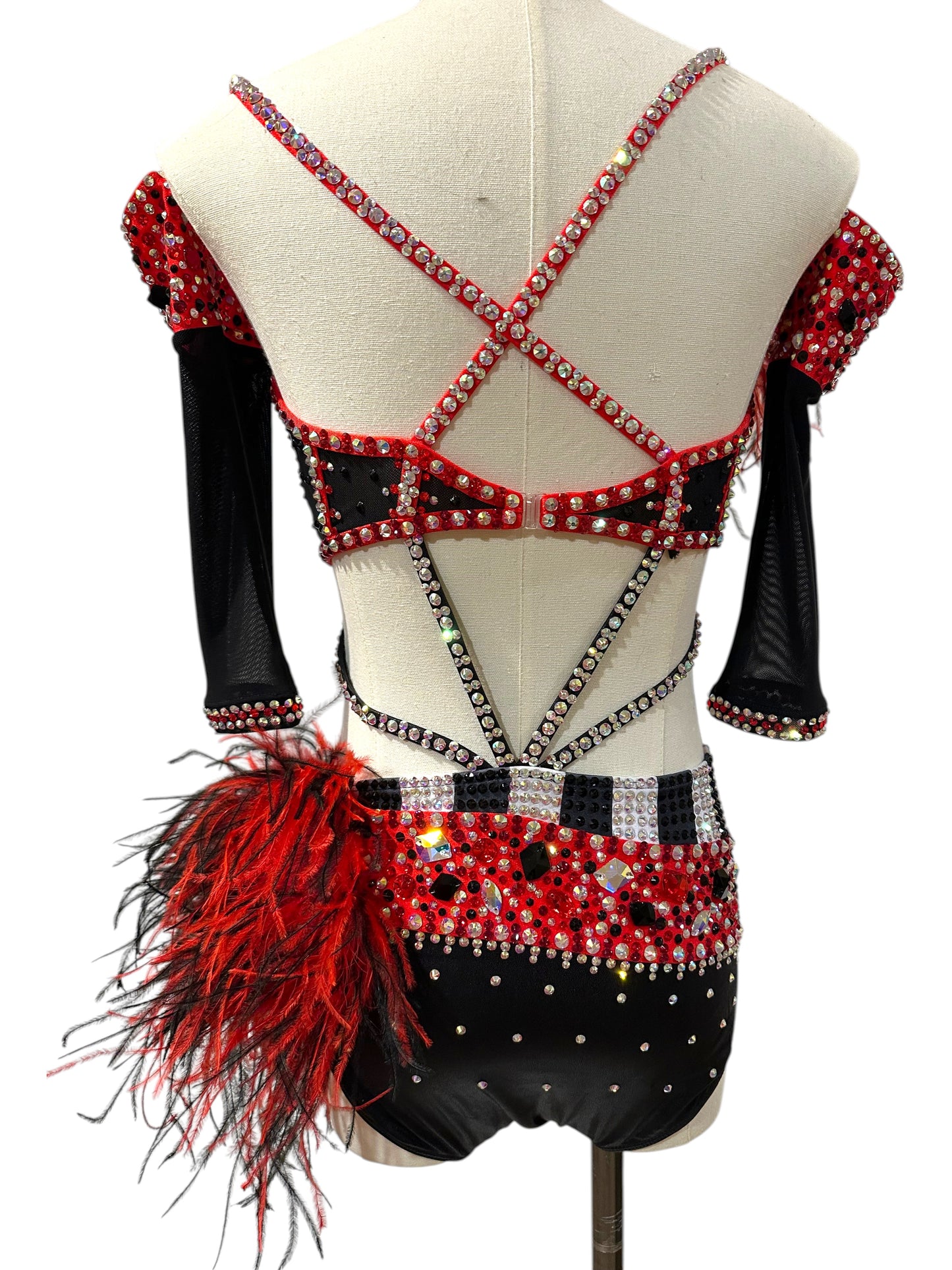 Back view of a ready-to-ship red, black and white competition dance costume featuring an open strappy back, rhinestones, feather bustle accent, and red beaded fringe.