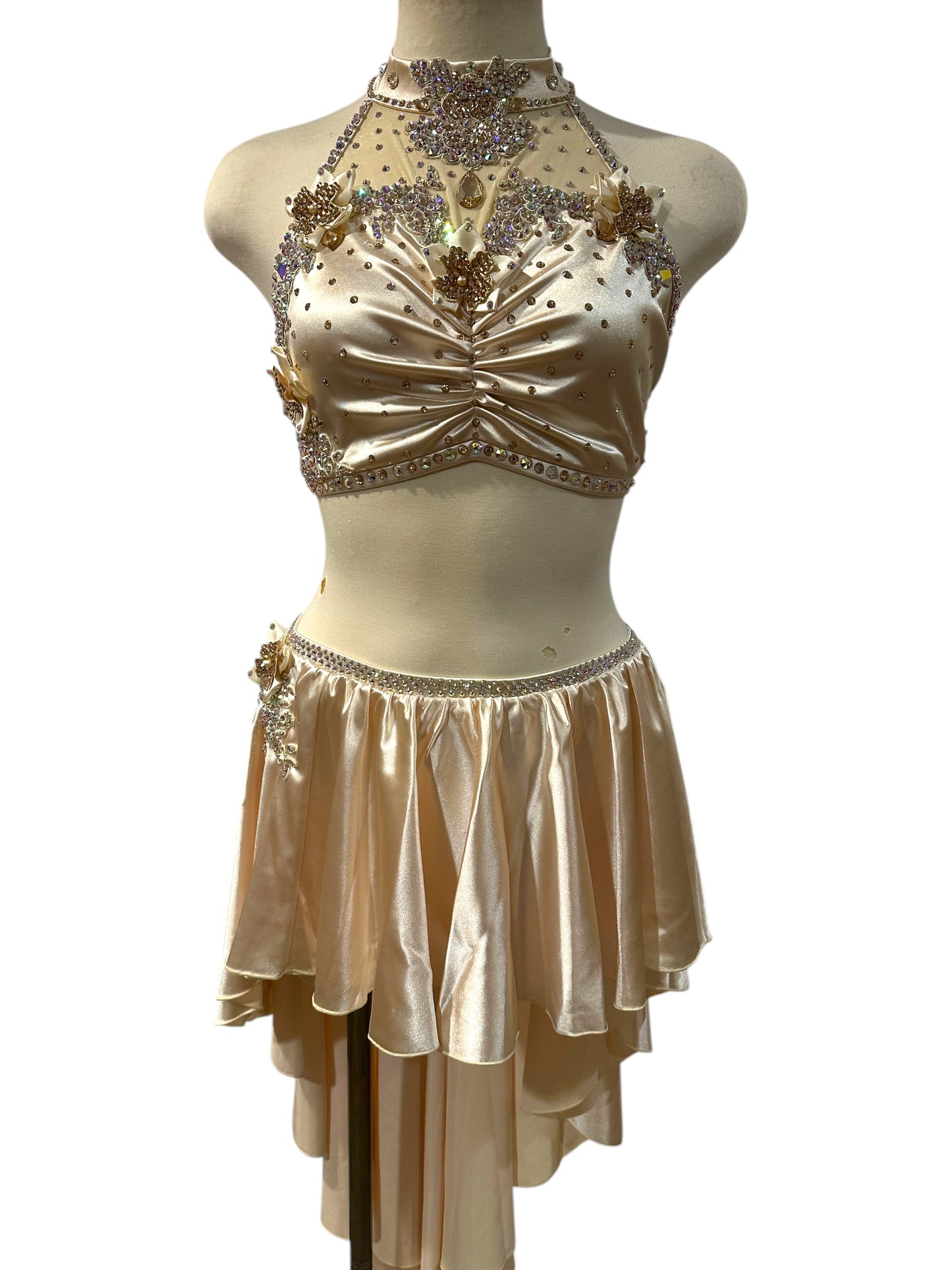 Front view of the Aubrey Ready-to-Ship dance costume in almond white satin featuring crystal appliqués, floral embellishments, a halter neckline, and an asymmetrical layered skirt.