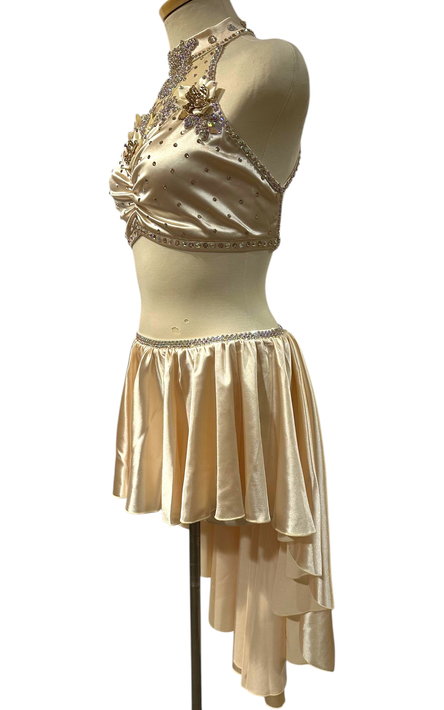 Left side view of the Almond white satin Ready-to-Ship dance costume highlighting crystal appliqués, floral accents, and an asymmetrical performance skirt.