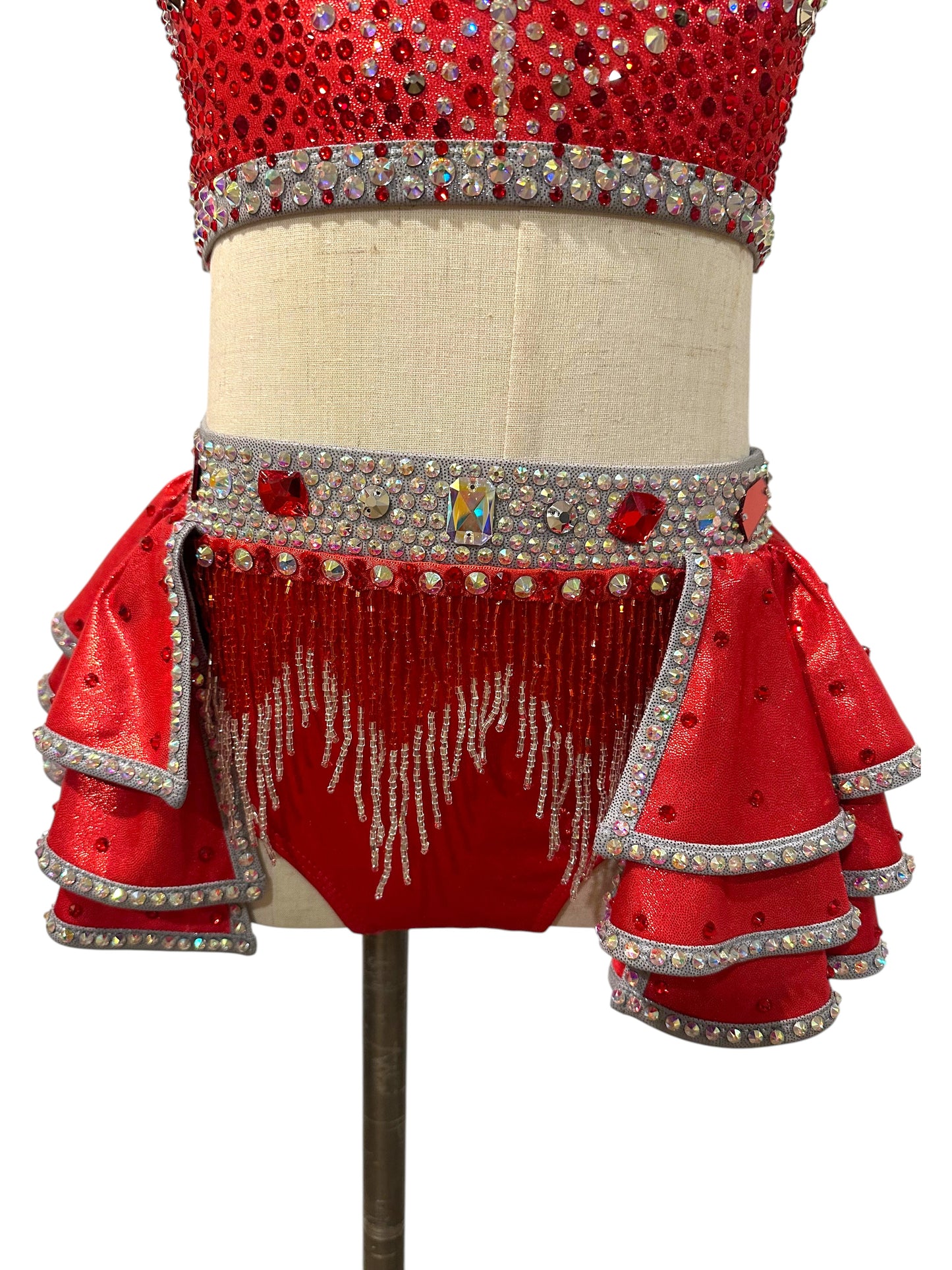 Close-up of the layered ruffle skirt, crystal waistband, and sparkling beaded fringe on the Kiki Ready-to-Ship dance costume.