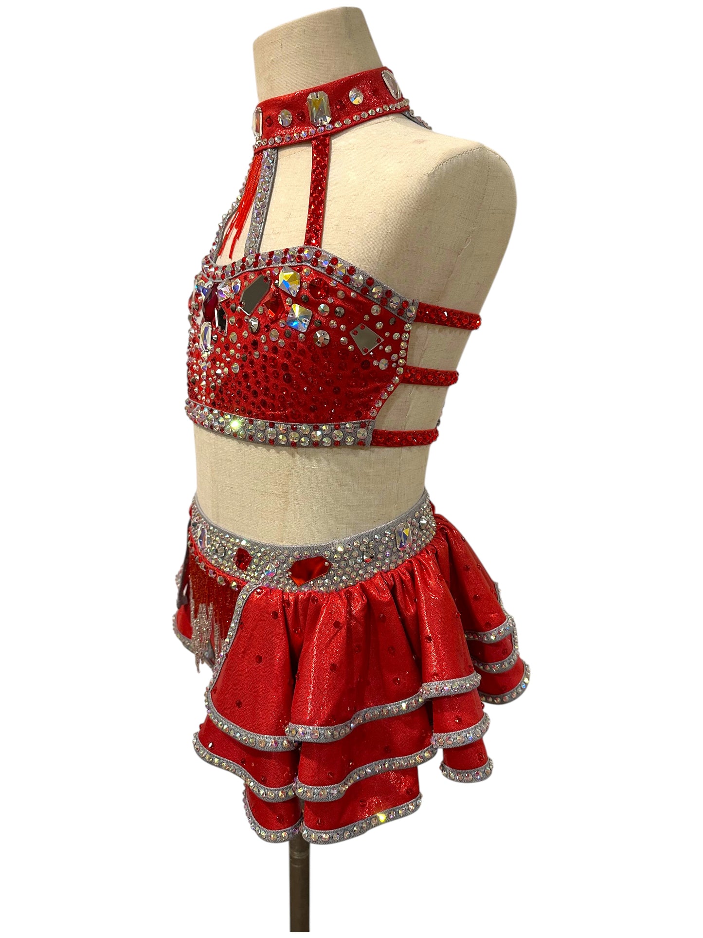 Left side view of the Kiki Ready-to-Ship dance costume featuring metallic fabric, layered ruffles, and premium crystal embellishments.