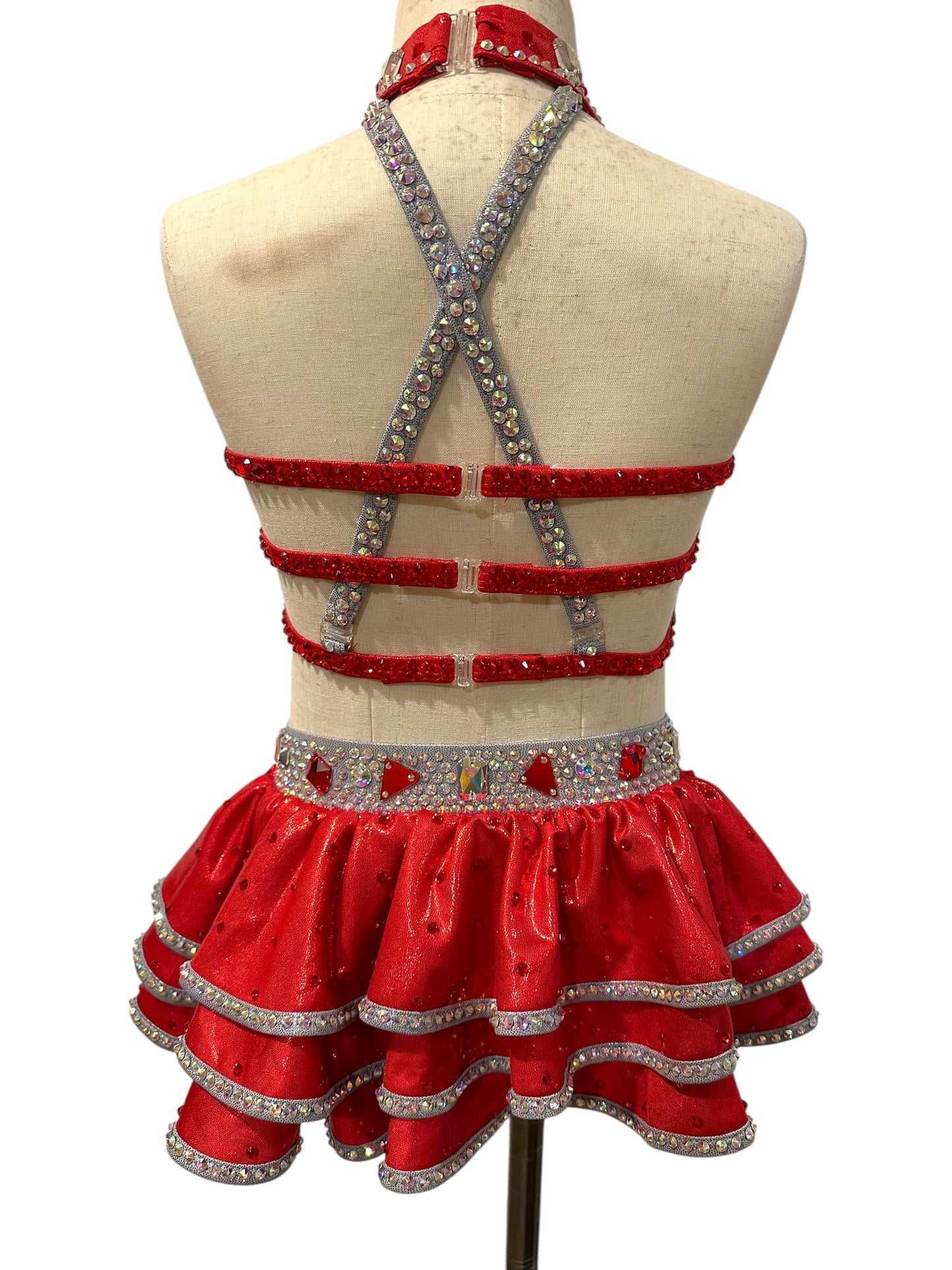 Back view of the Kiki Ready-to-Ship dance costume featuring a strappy open-back design, crystal straps, and layered ruffle skirt.