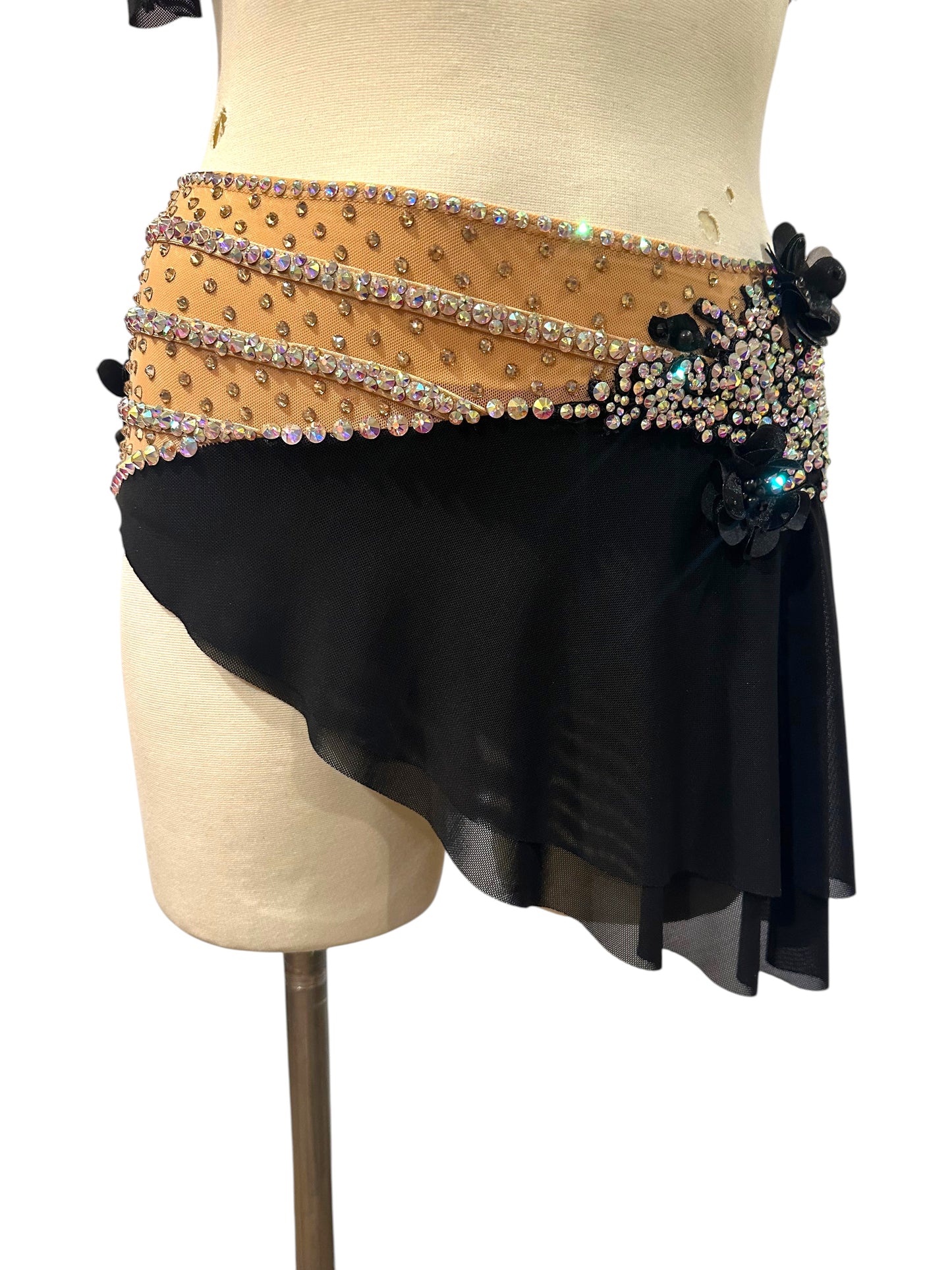 Close-up of Scarlett black mesh dance skirt with crystal-trimmed nude waistband and black floral appliqués.