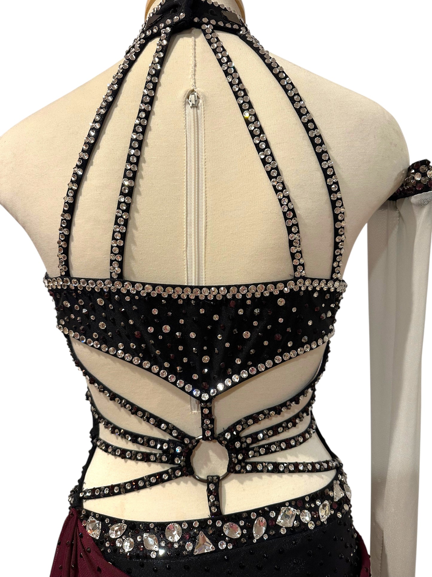 Upper back view of black Ready-to-Ship dance costume with rhinestone straps, open back construction and crystal detailing.