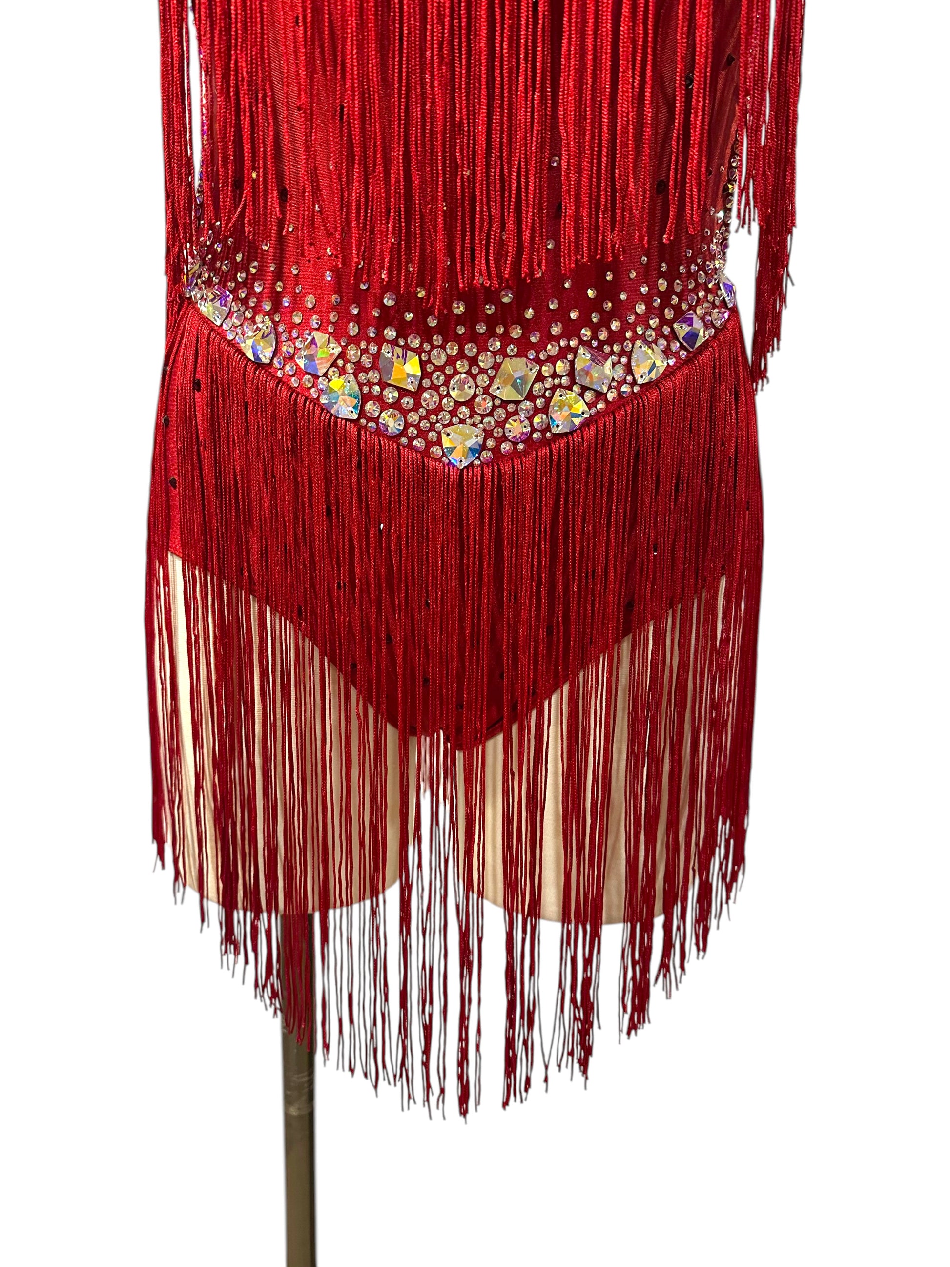 Close-up of red fringe dance costume with crystal waistband, AB statement stones, rhinestones, and layered fringe at the hips.