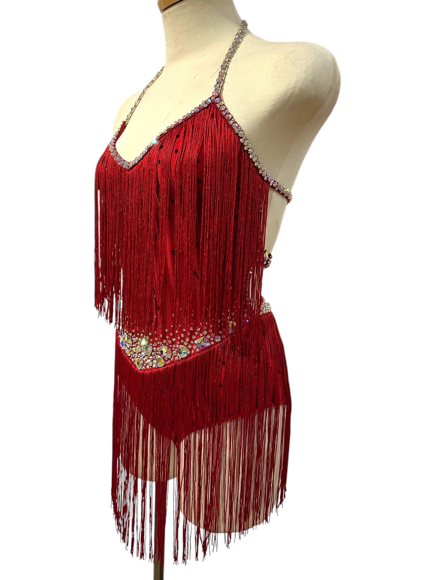 Side angled view of red fringe dance costume with sparkling rhinestone trim, statement crystals, and full fringe movement.