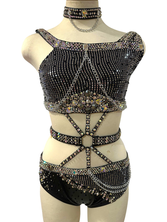 Front view of exclusive black and silver Adult Small dance costume with rhinestones, hologram fabric, silver chains, and strappy waist detailing.