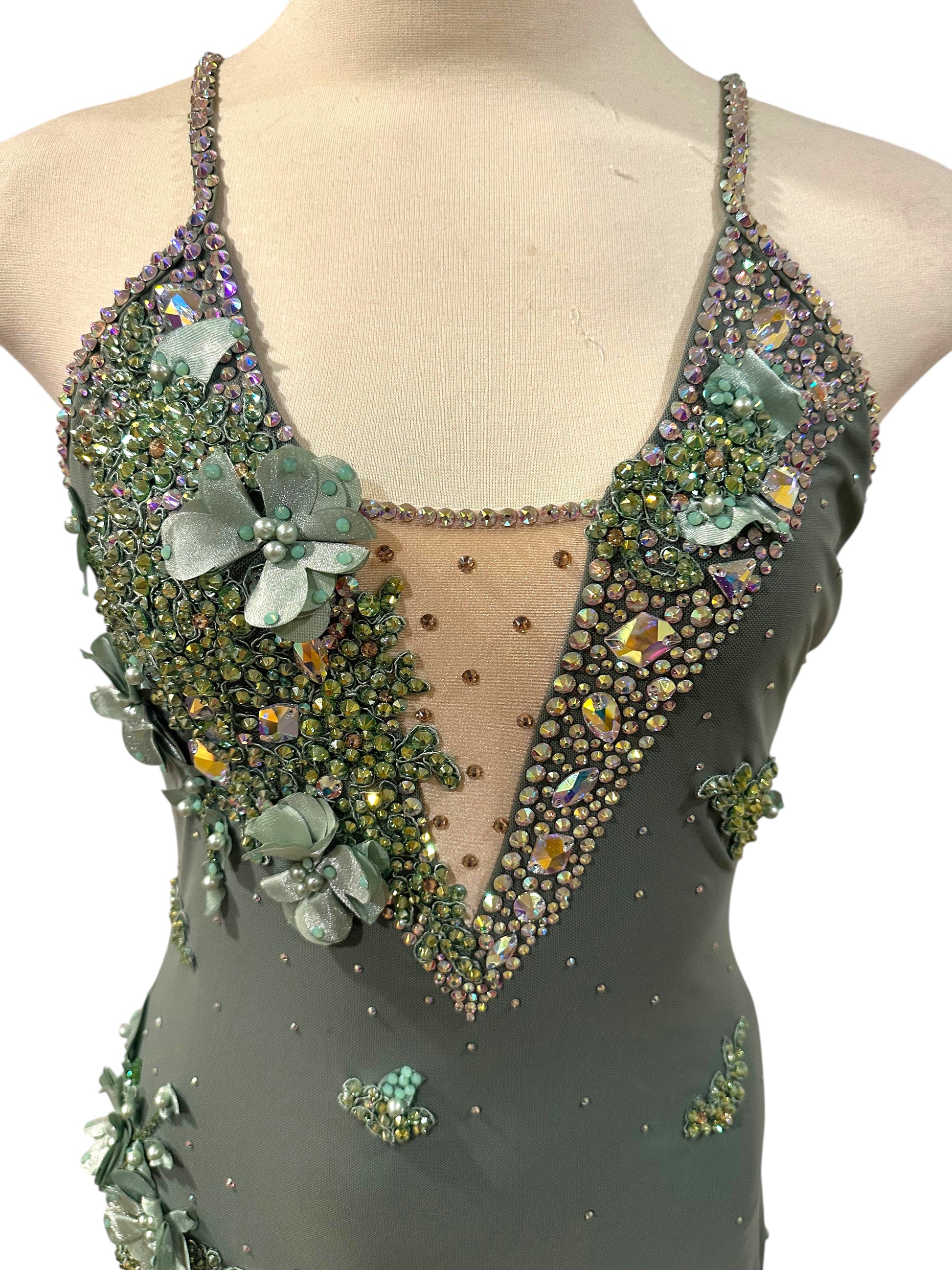 Close-up of olive-green dance costume featuring rhinestone appliqué detailing, nude mesh inset, and elegant lyrical styling.