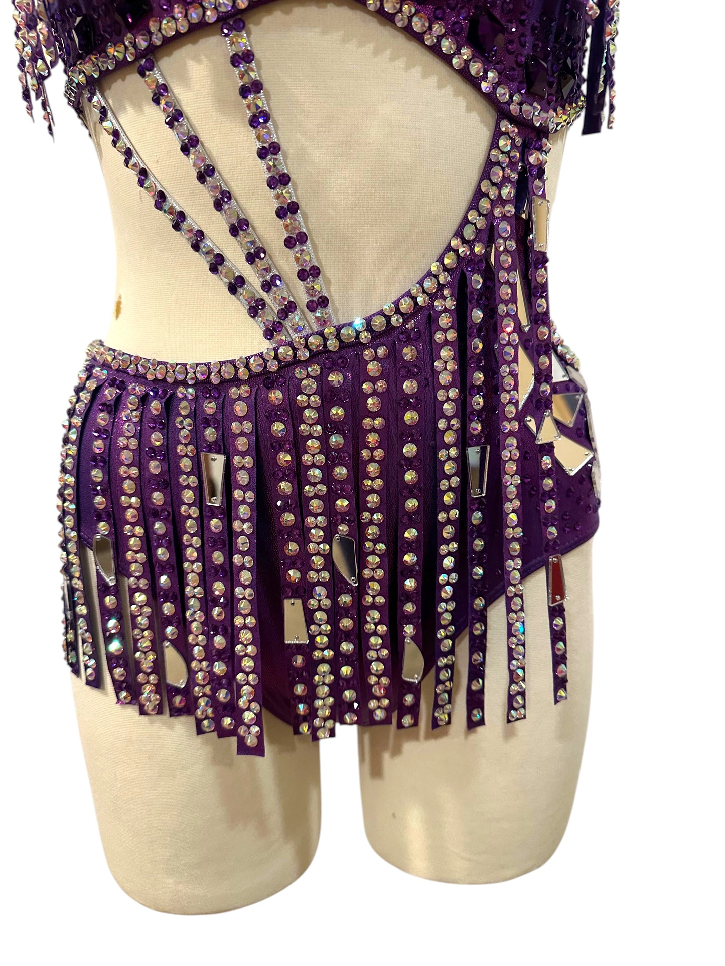 Close-up of hologram purple dance costume featuring mirror accents, rhinestone embellishments, and intricate competition costume detailing.