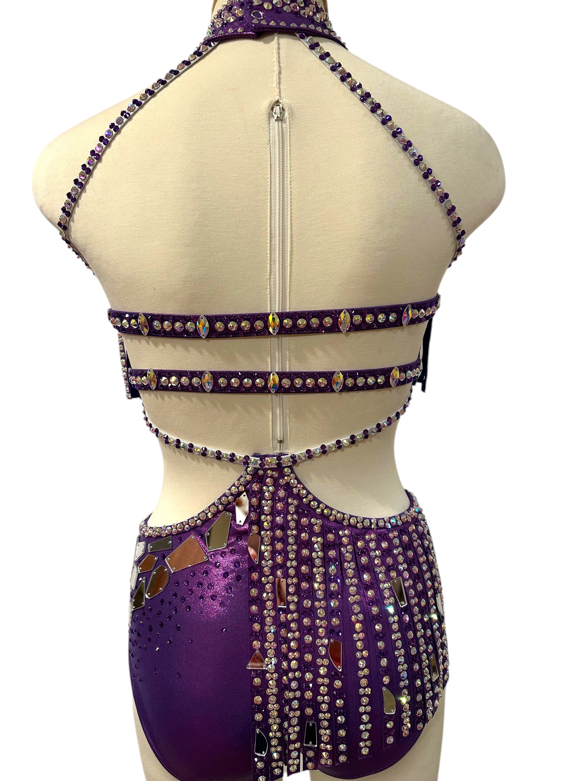 Back view of purple dance costume highlighting strappy construction, rhinestone accents, and secure performance fit.