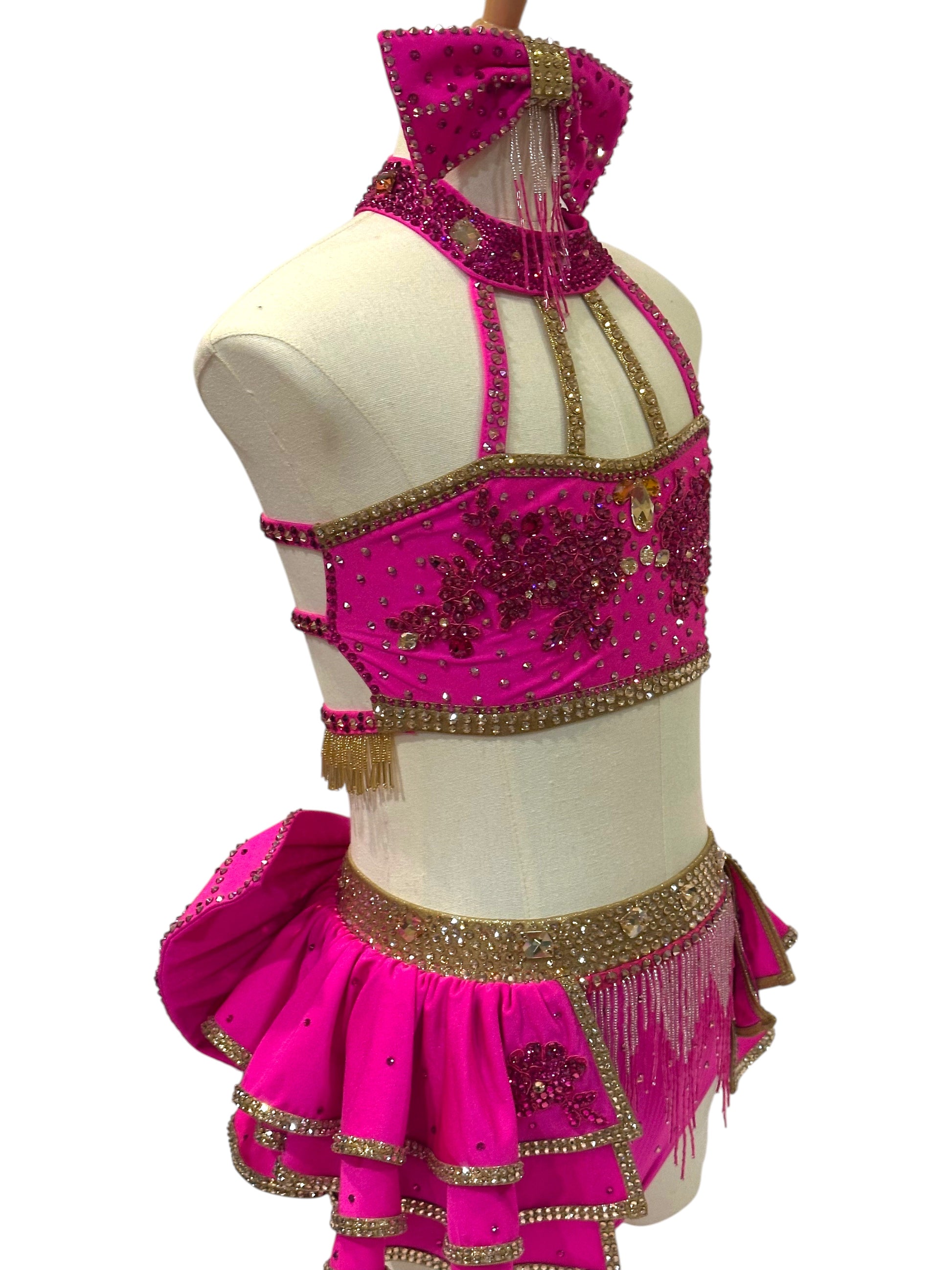 Angled view of Child Large hot pink dance costume with gold accents, rhinestone embellishments, and high-impact stage presence.
