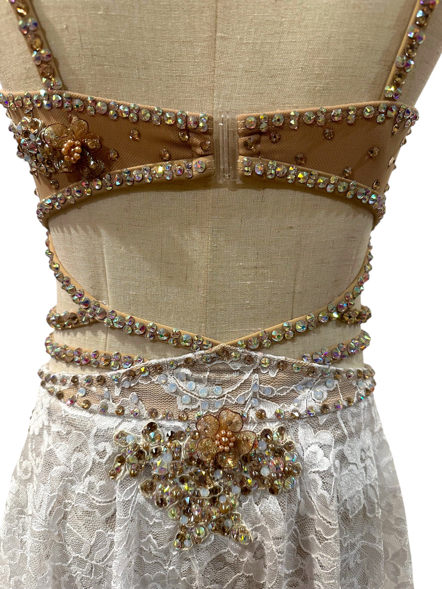 White lace dance costume back detail featuring crystal appliqué and strap design