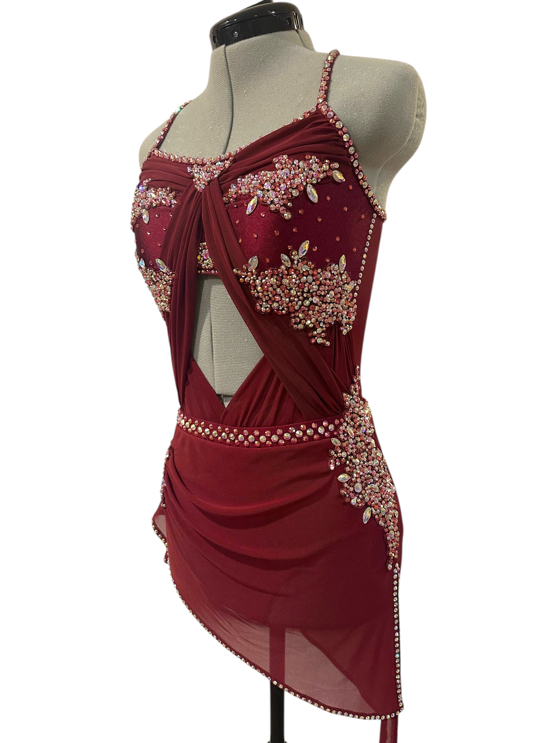 Side view of ready-to-ship burgundy dance costume featuring rhinestone hip appliqué, open side detailing, and asymmetrical skirt
