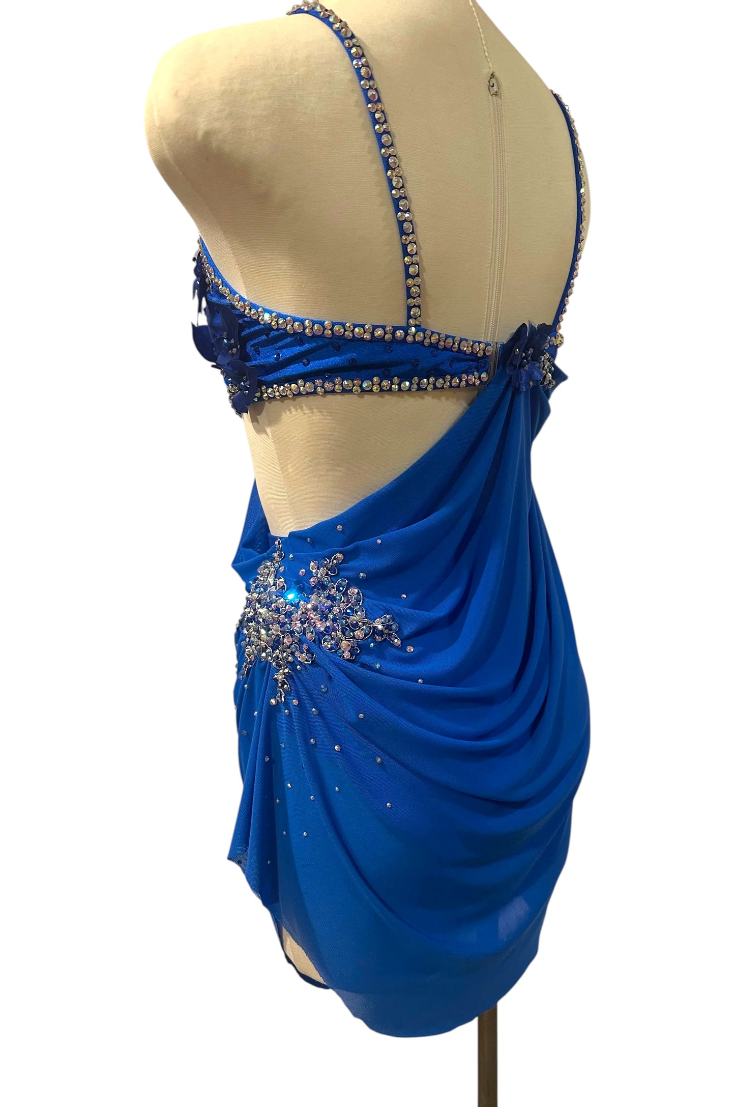 Left side view of royal blue couture dance costume featuring elegant mesh draping and sparkling crystal embellishments.
