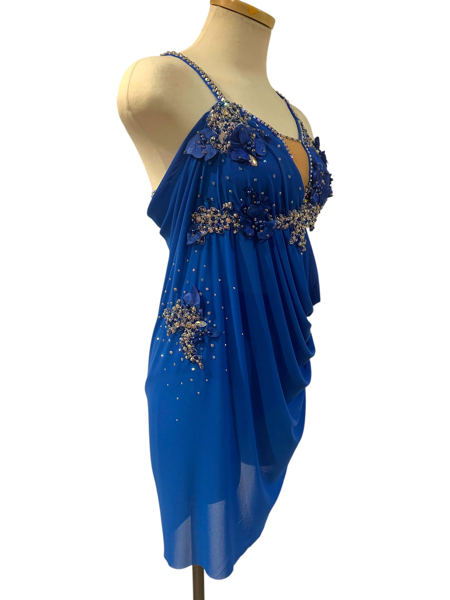 Right angled view of royal blue lyrical dance costume showcasing rhinestone detailing, floral appliqués, and soft draped mesh.