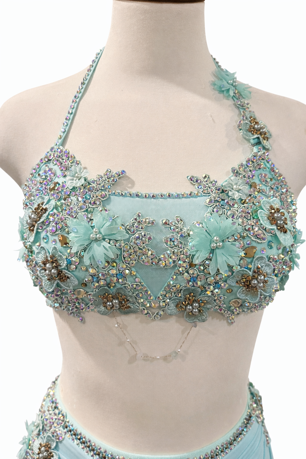 Dance costume inspiration detail featuring rhinestone embellishment and floral appliqué