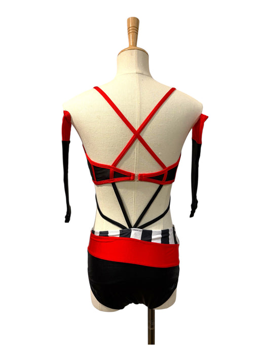 Back view of the Kat Base dance costume showing crisscross straps, open back design, striped waistband, and detachable sleeves.