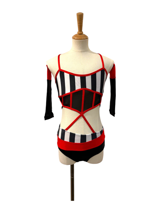 Kat Base made-to-order dance costume front view featuring black and white striped bodice, illusion mesh corset, red trim, and detachable sleeves.