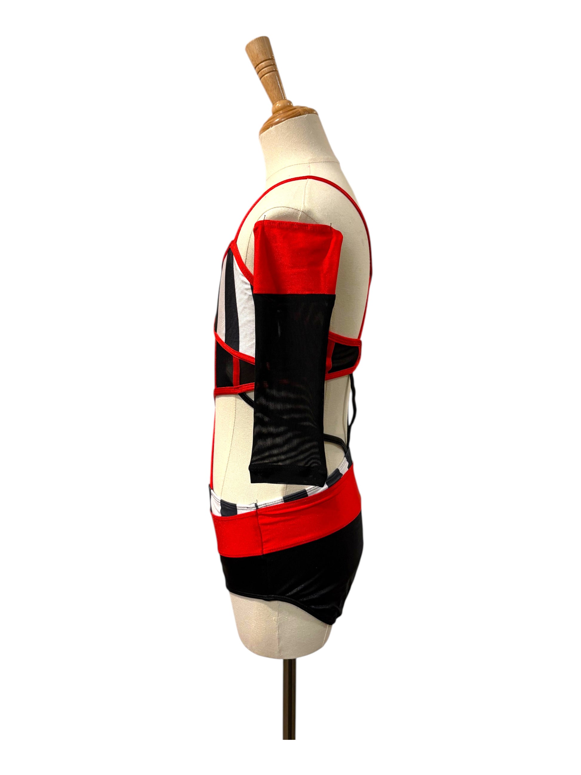Left side view of the Kat Base dance costume showcasing the open side silhouette, striped waistband, and detachable sleeve.