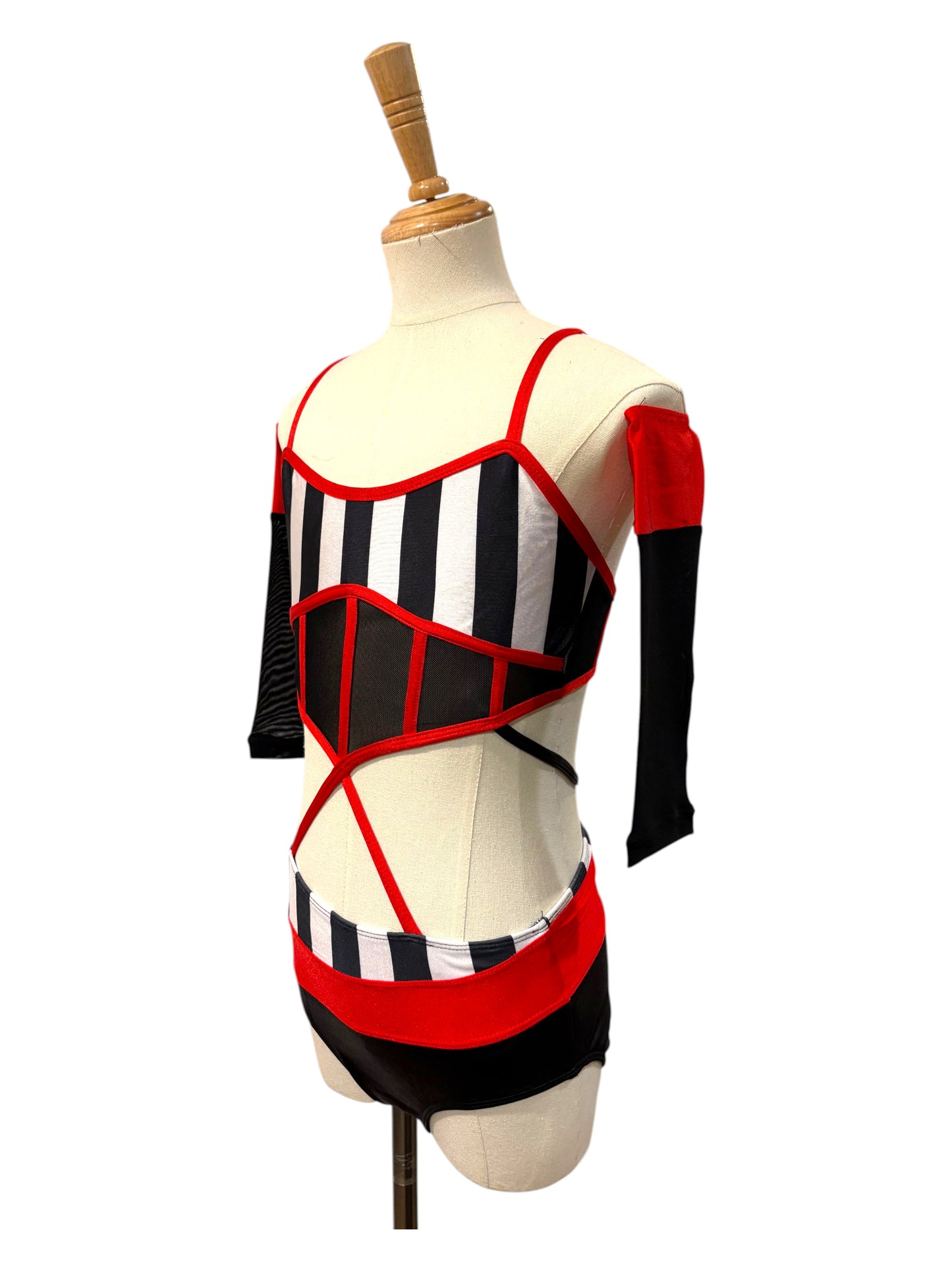 Left side profile of the Kat Base dance costume featuring dramatic cutouts, red trim, and breathable illusion mesh construction.