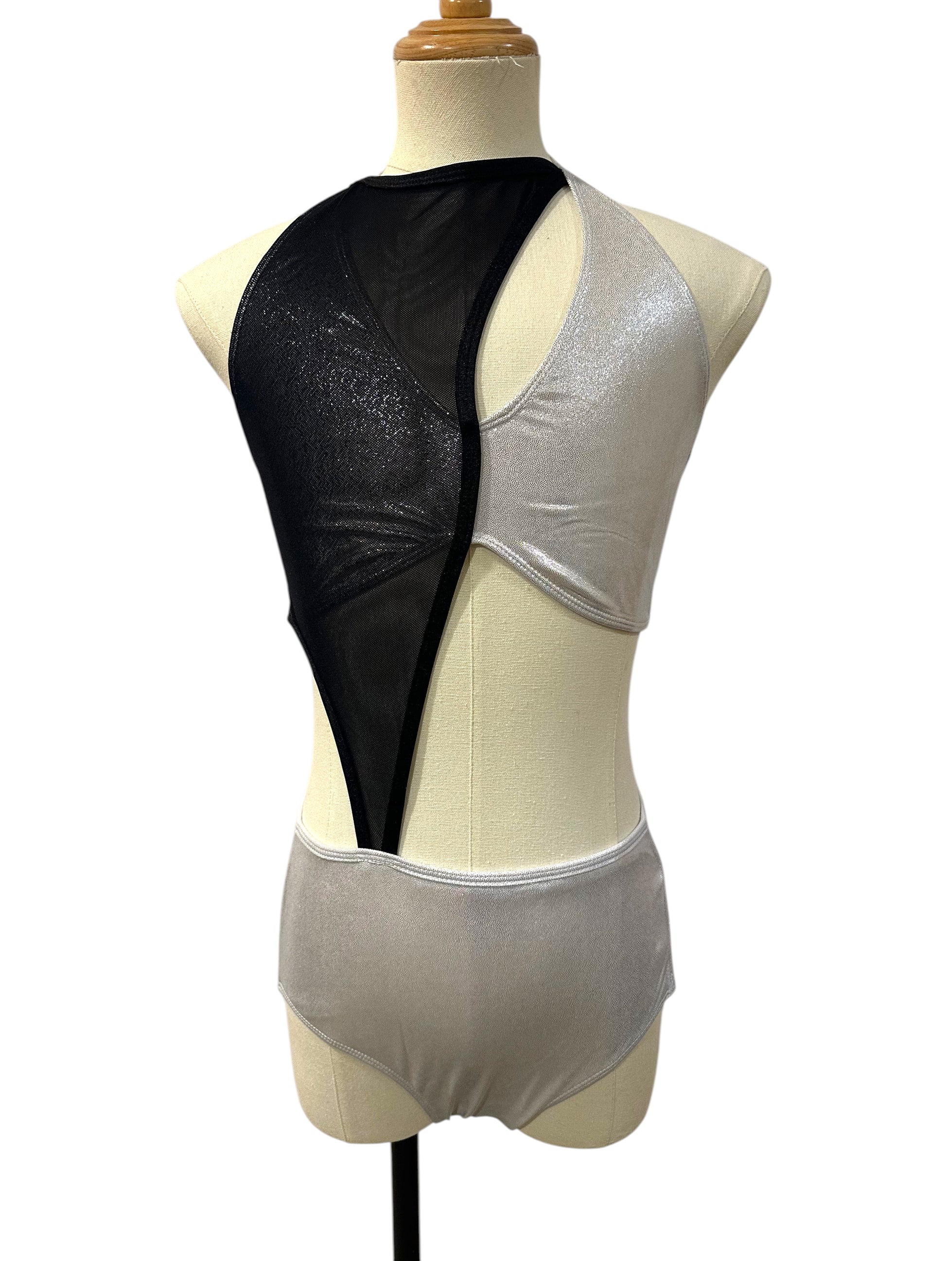 Vita Base dance costume in black and grey featuring dramatic asymmetrical color blocking, high neckline, and contemporary cutout design front view